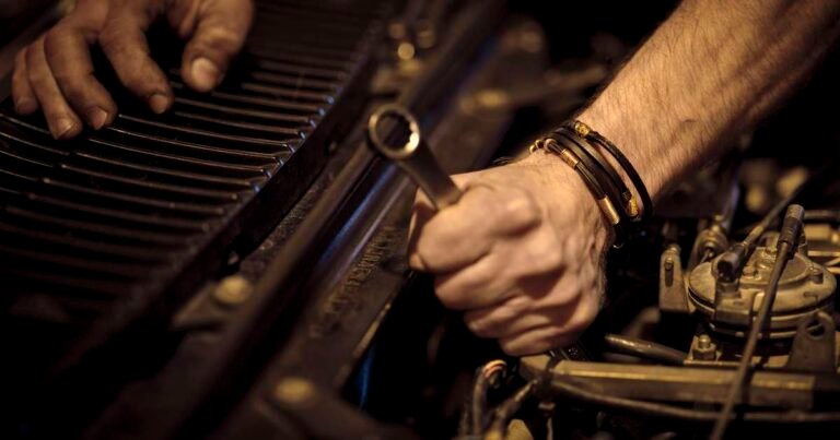 Mechanic hands inspecting and repairing an engine for tractor troubleshooting guide