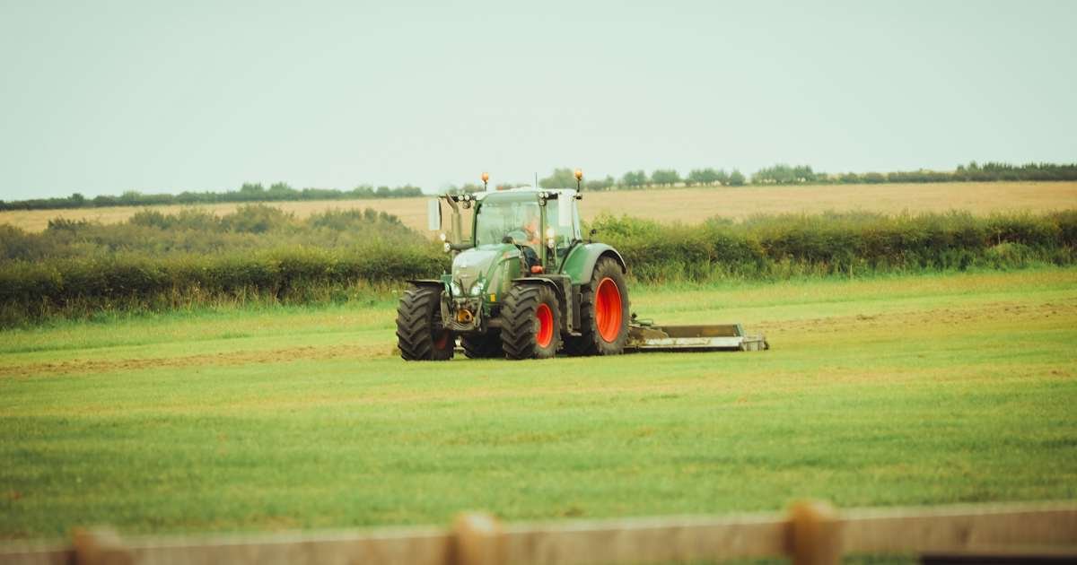 Compact tractor parked on rural property for tractor sizing guide